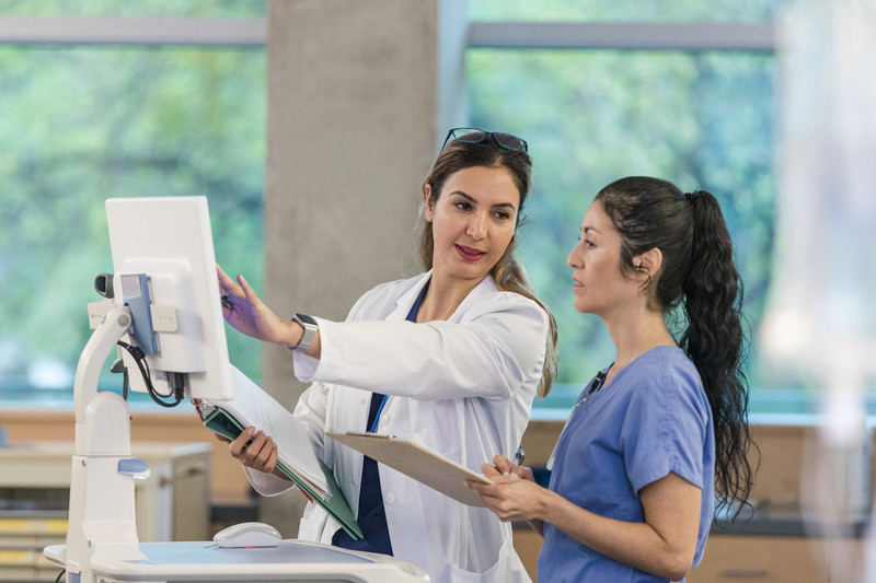 female nurse and doctor standing at a computer